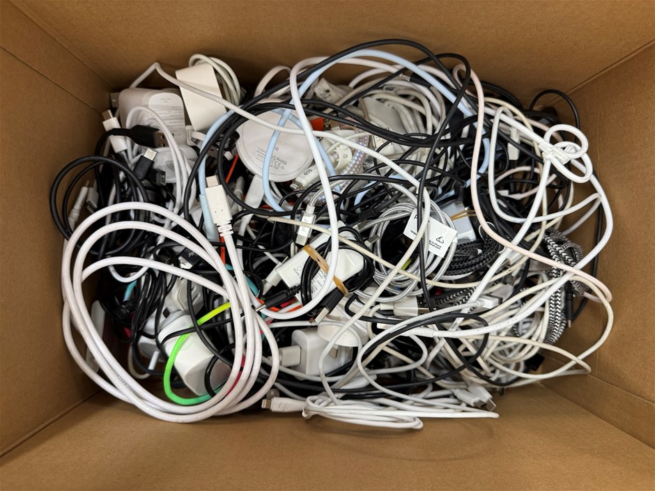 Box containing a quantity of assorted phone chargers and cords.
